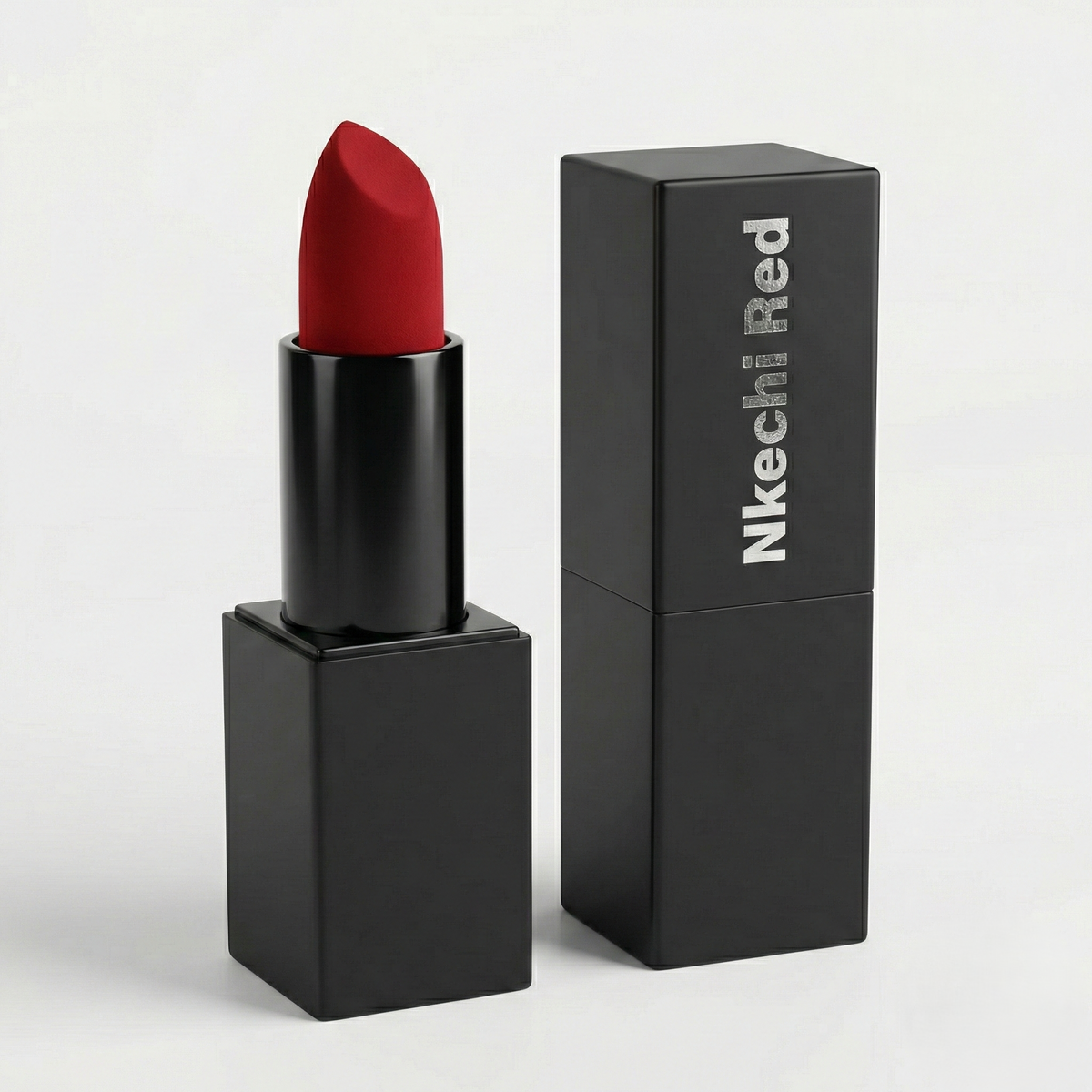 Nkechi Red Velvet Matte Lipstick, a bold red bullet in a black case beside its black box